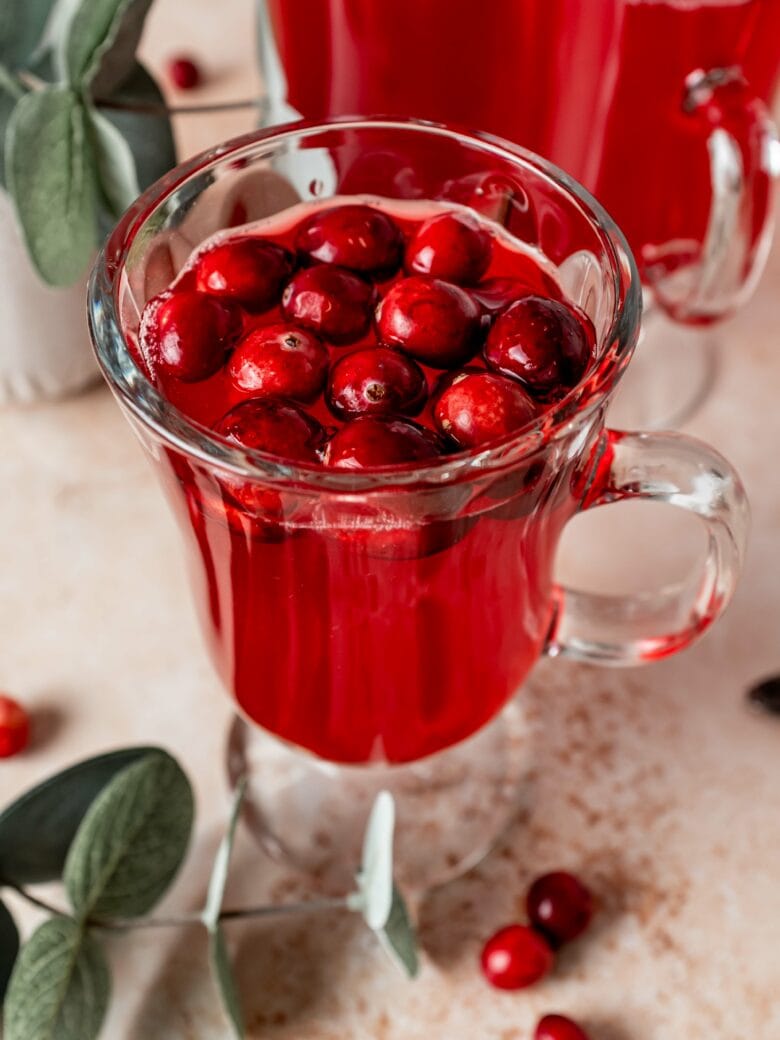 Mors in a glass with fresh cranberry garnish.