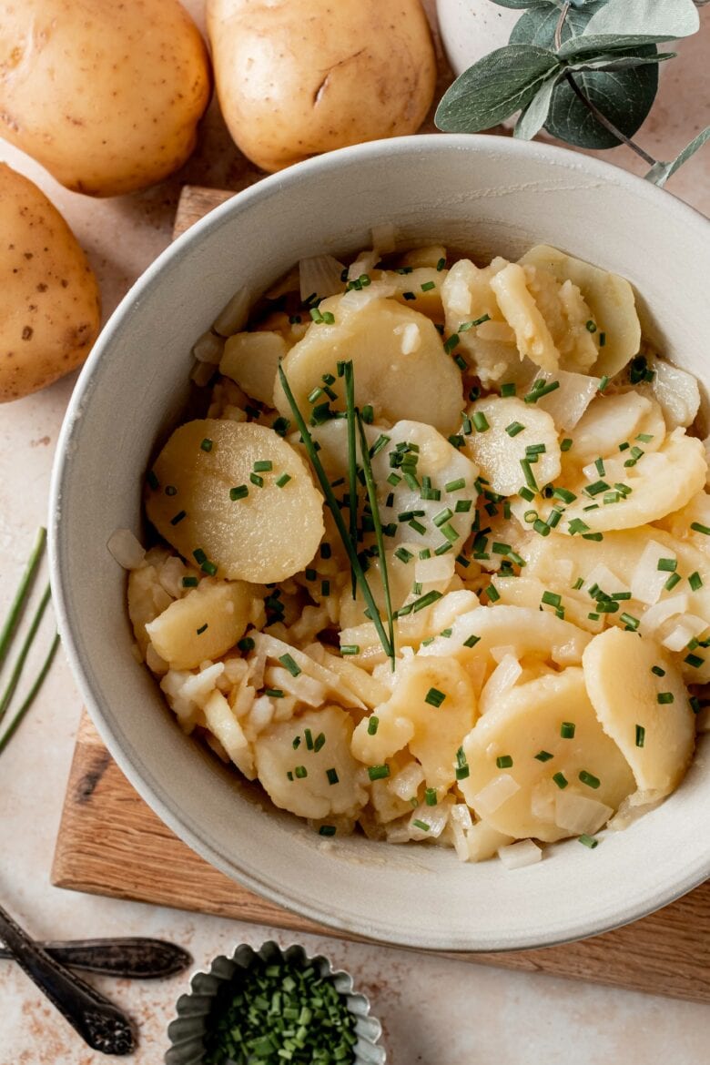 Potato salad in serving bowl with chopped chives.