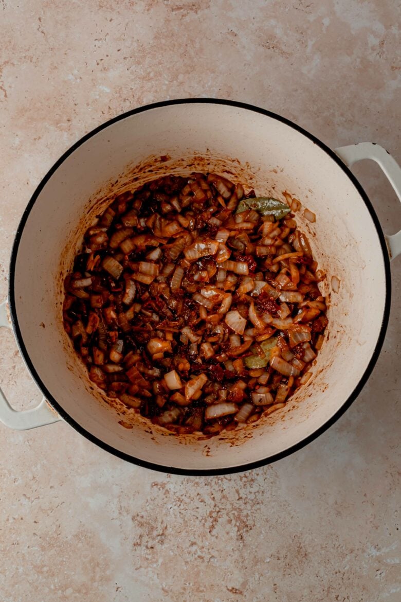 Onions with spices and chipotles in adobo in dutch oven.