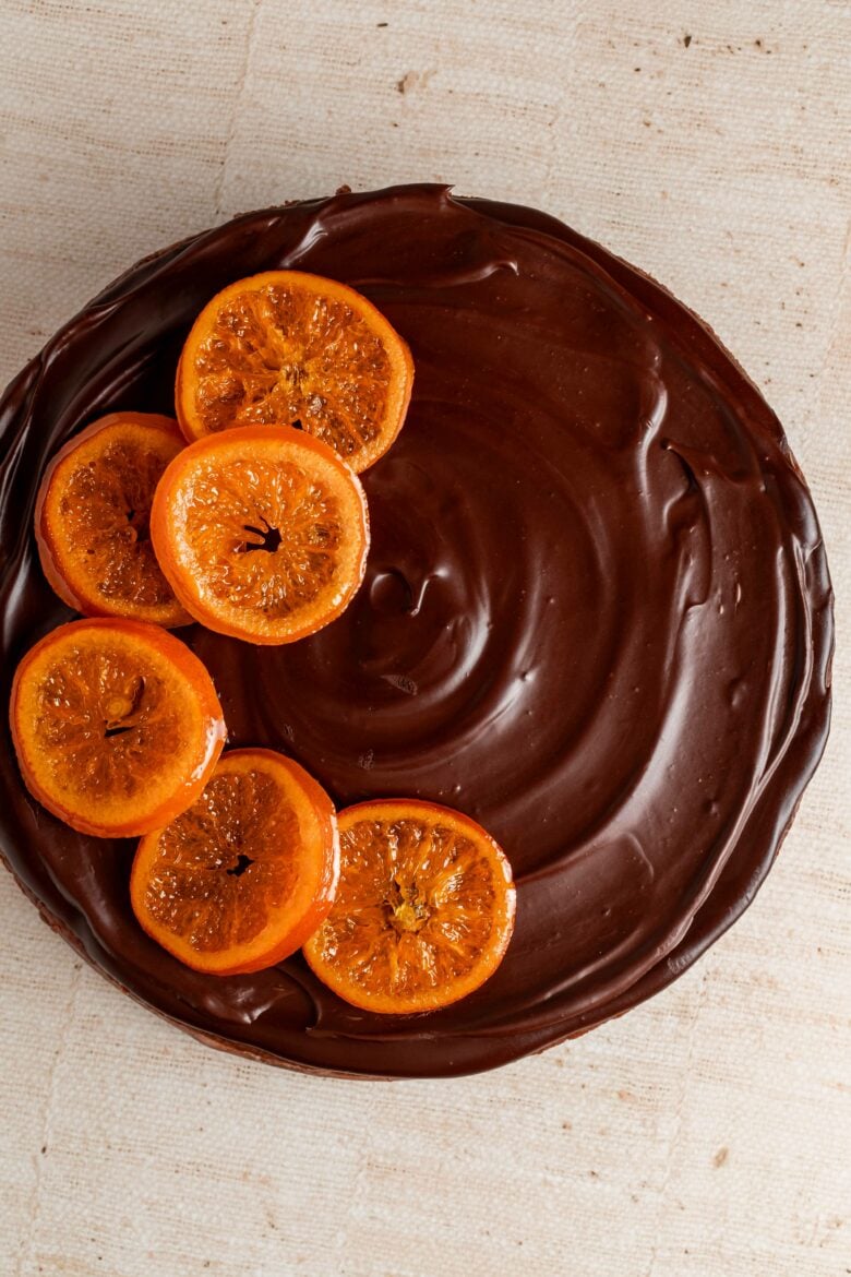 Cheesecake topped with chocolate ganache and candied oranges.