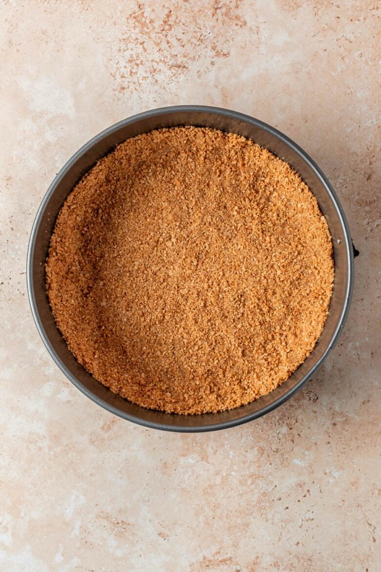 Formed graham cracker crust in springform pan.