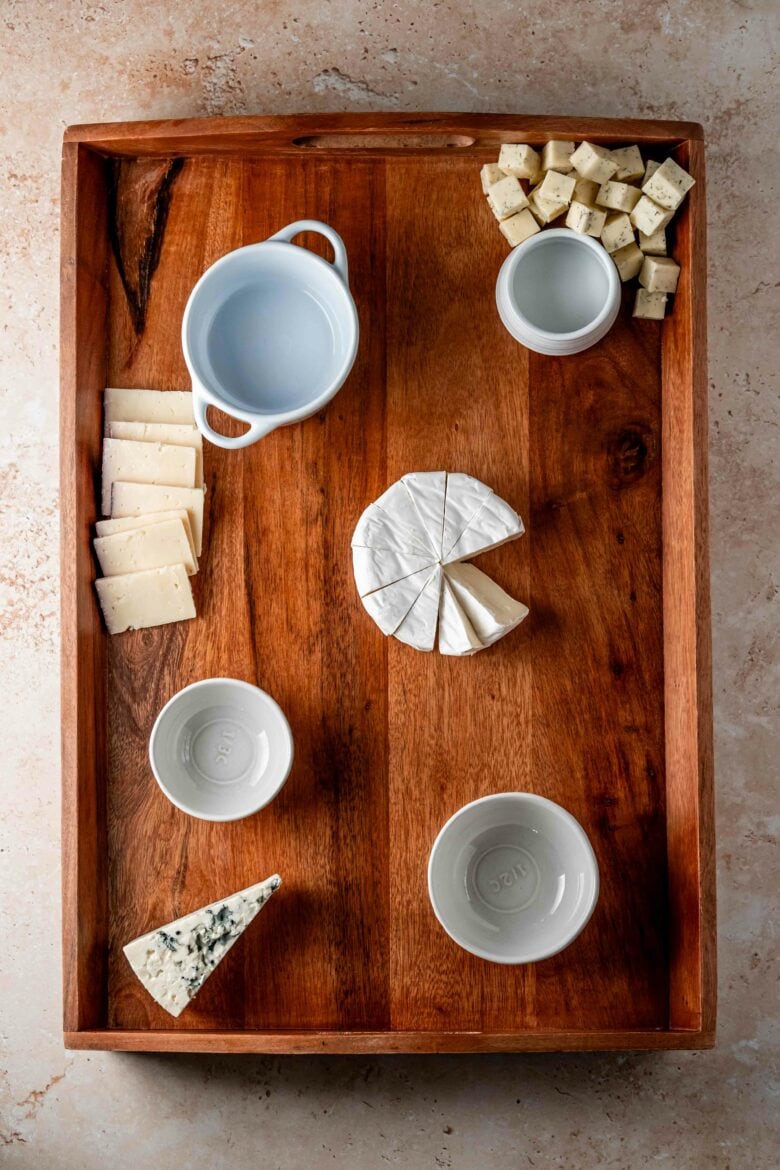 Step 2: Cut the cheeses into various shapes and place on the board.
