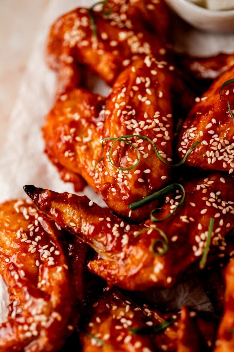 Gochujang chicken wings with sesame seeds and green onion.