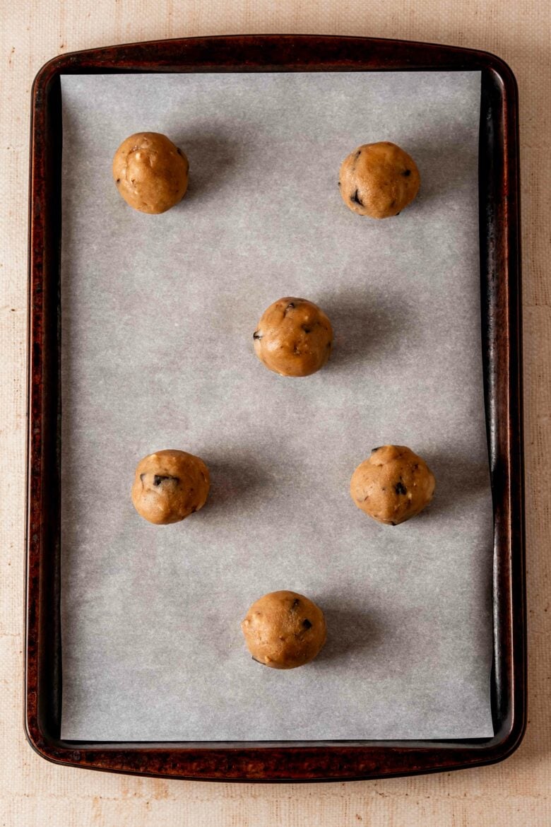 Cookie dough balls on baking sheet with parchment paper.