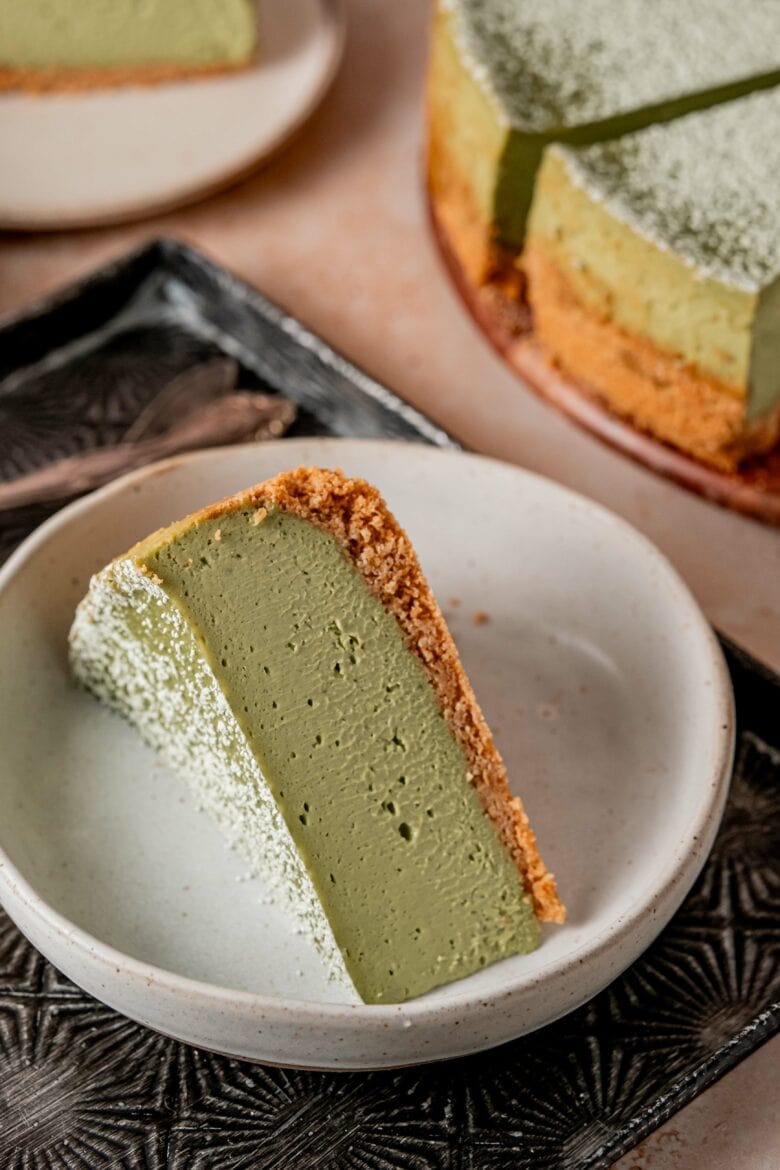 Slice of beautifully green cheesecake on a small plate.