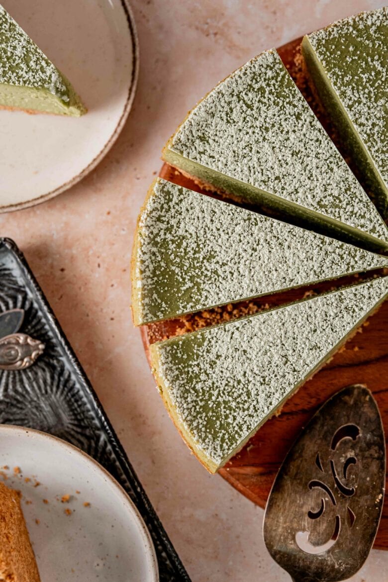 Overhead view of matcha cheesecake cut into slices.