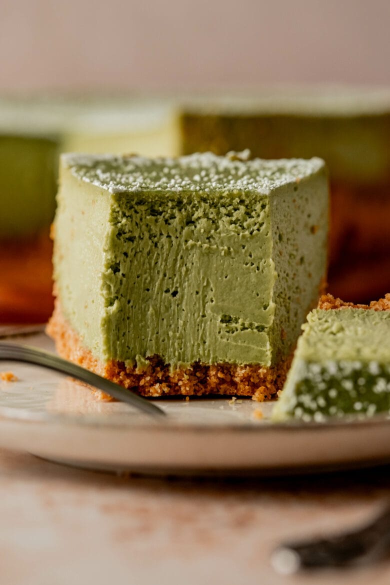 Bite taken out of matcha cheesecake to reveal ultra creamy texture.