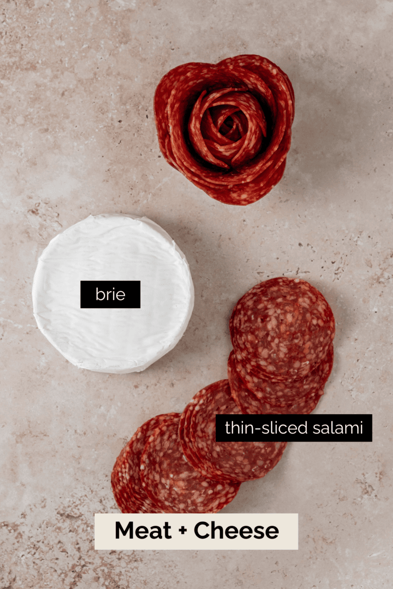 Brie cheese wheel, thinly-sliced salami and a salami rose.