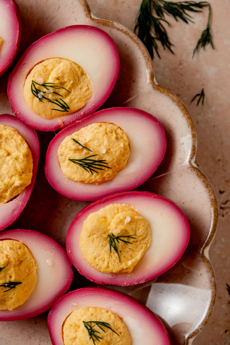 Brightly colored deviled eggs arranged on a platter.