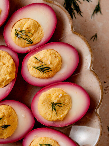 Close-up of halved deviled eggs showcasing rich pink color from beet brine.