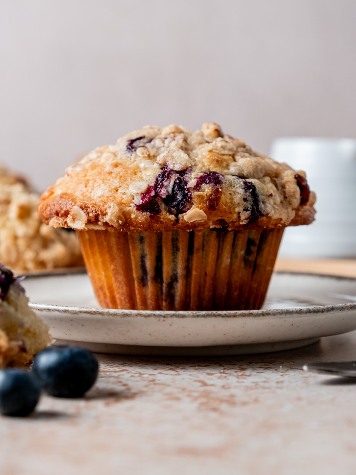 Close up of freshly baked blueberry muffin with pecan oat streusel.