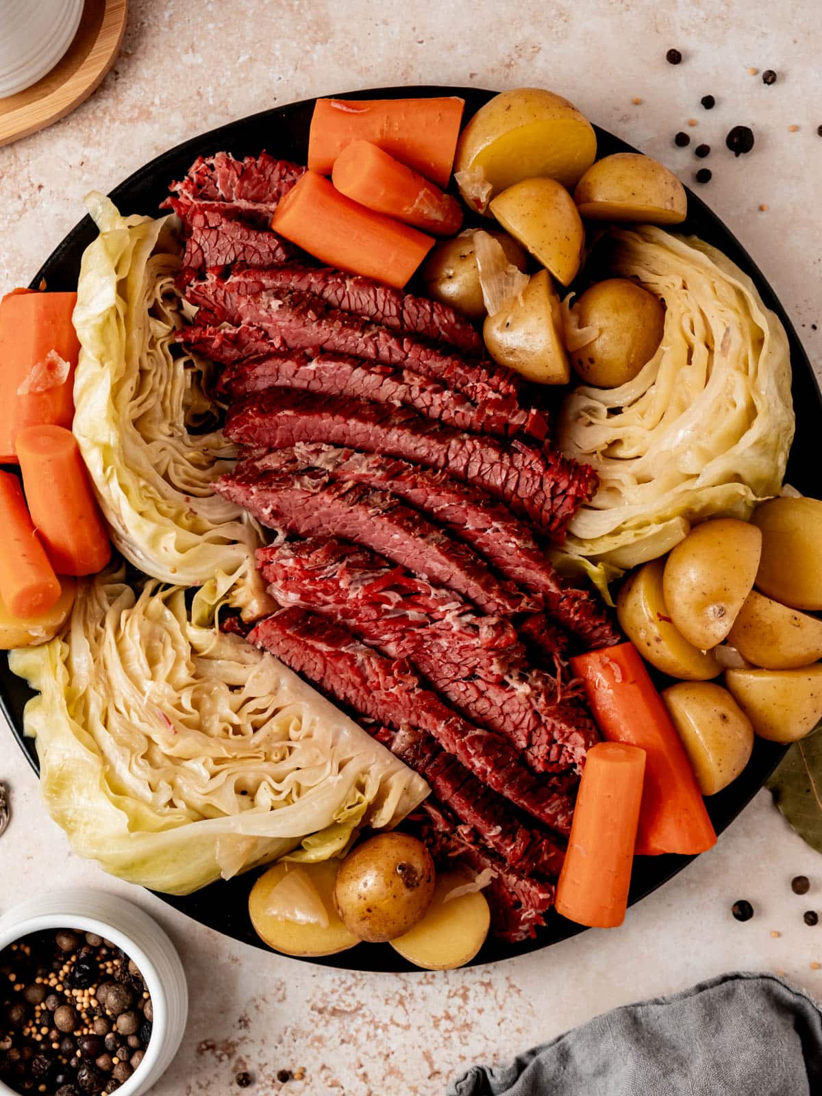 Platter with sliced corned beef, cabbage wedges, potatoes and carrots.