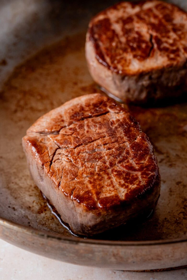 Seared filet mignon steaks in pan.