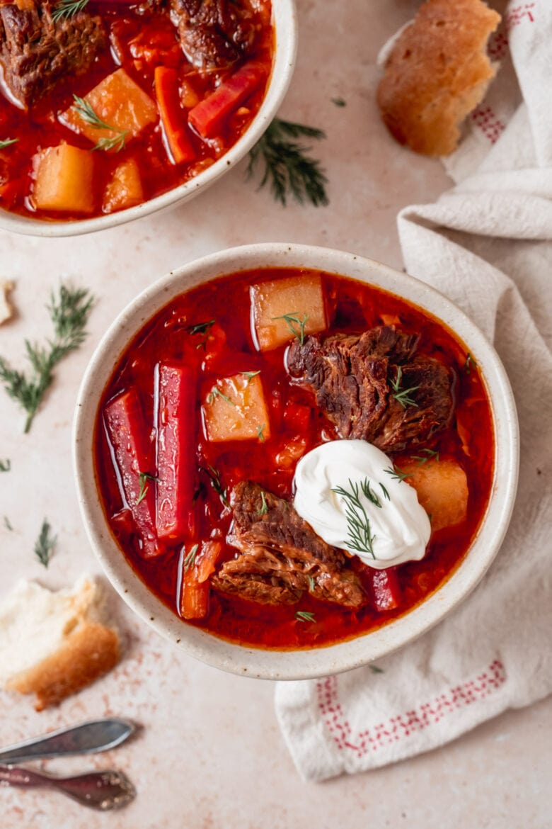 Bowl of comforting borscht with dollop of sour cream and fresh dill.