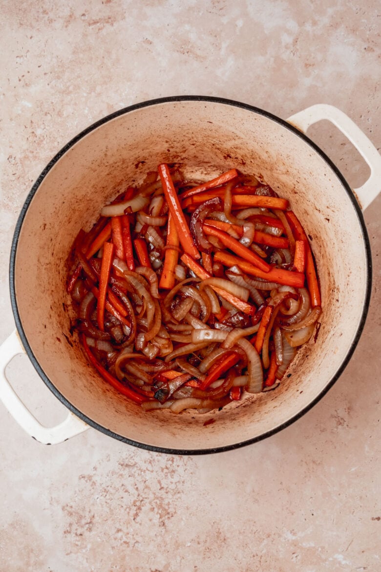 Sauteed carrots and onion in pot.