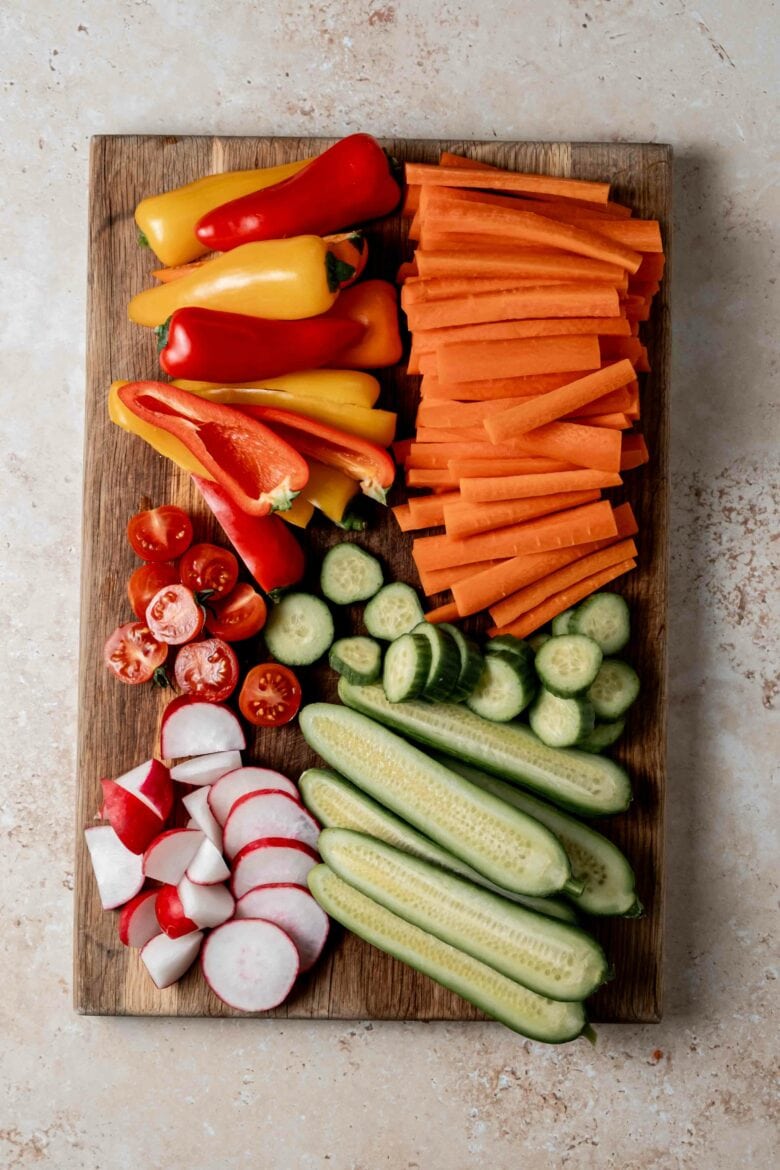 Vegetables prepared and cut on a wooden board.