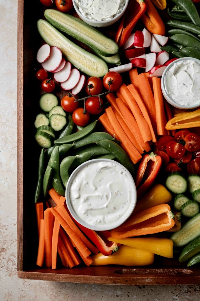 Assorted vegetables cut and arranged on a tray with various dips.