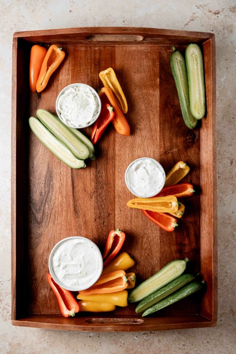 Dips and large veggies arranged on a serving tray.
