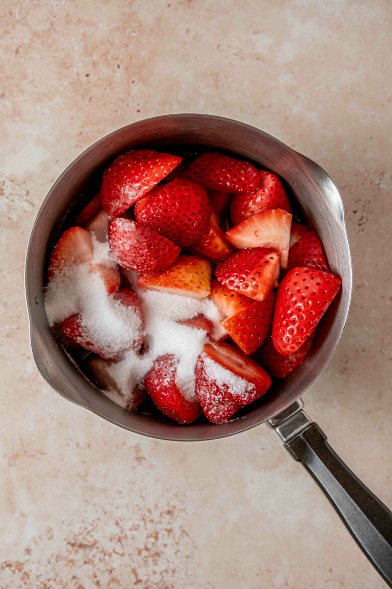 Halved strawberries and sugar in small saucepan.