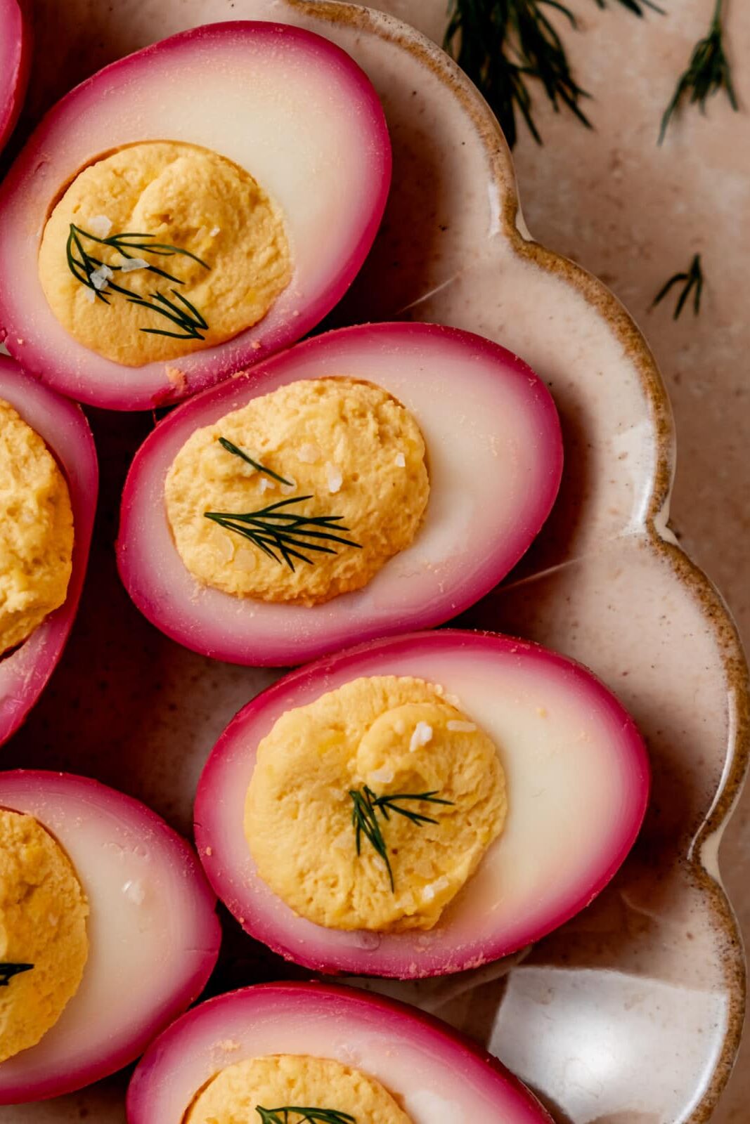 Close-up of halved deviled eggs showcasing rich pink color from beet brine.