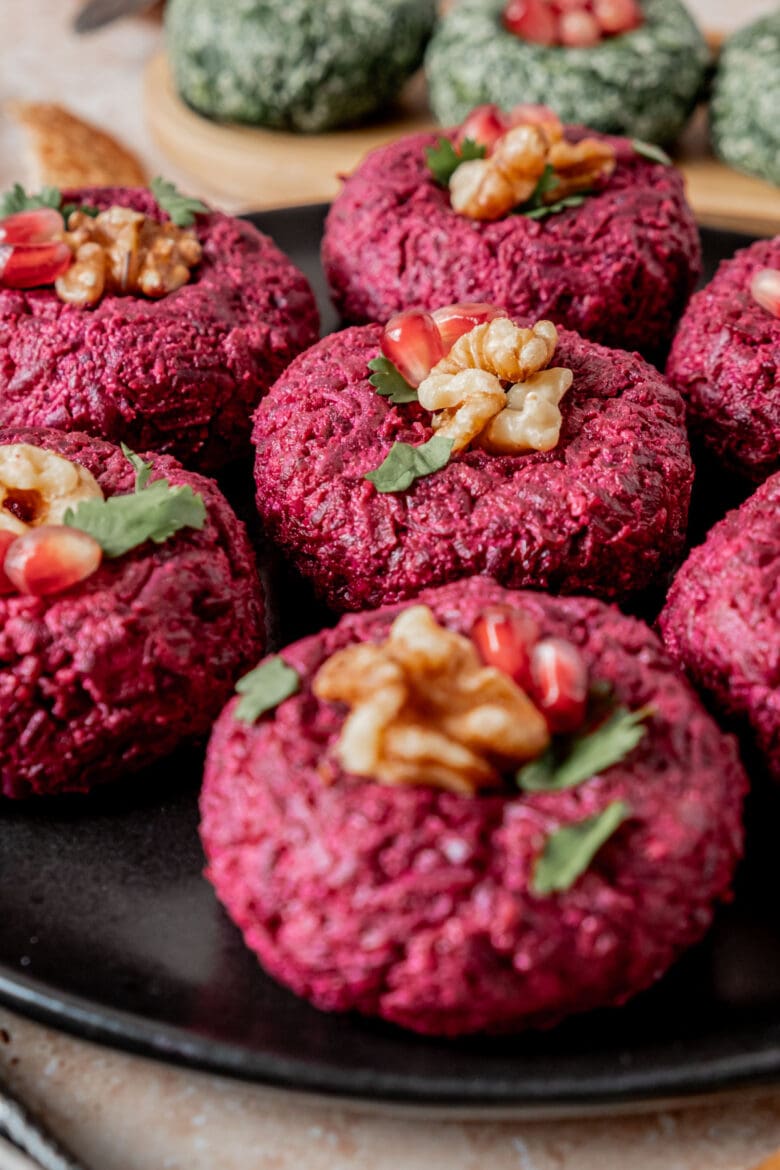 Close up of beet Pkhali on a plate garnished with walnuts and cilantro.