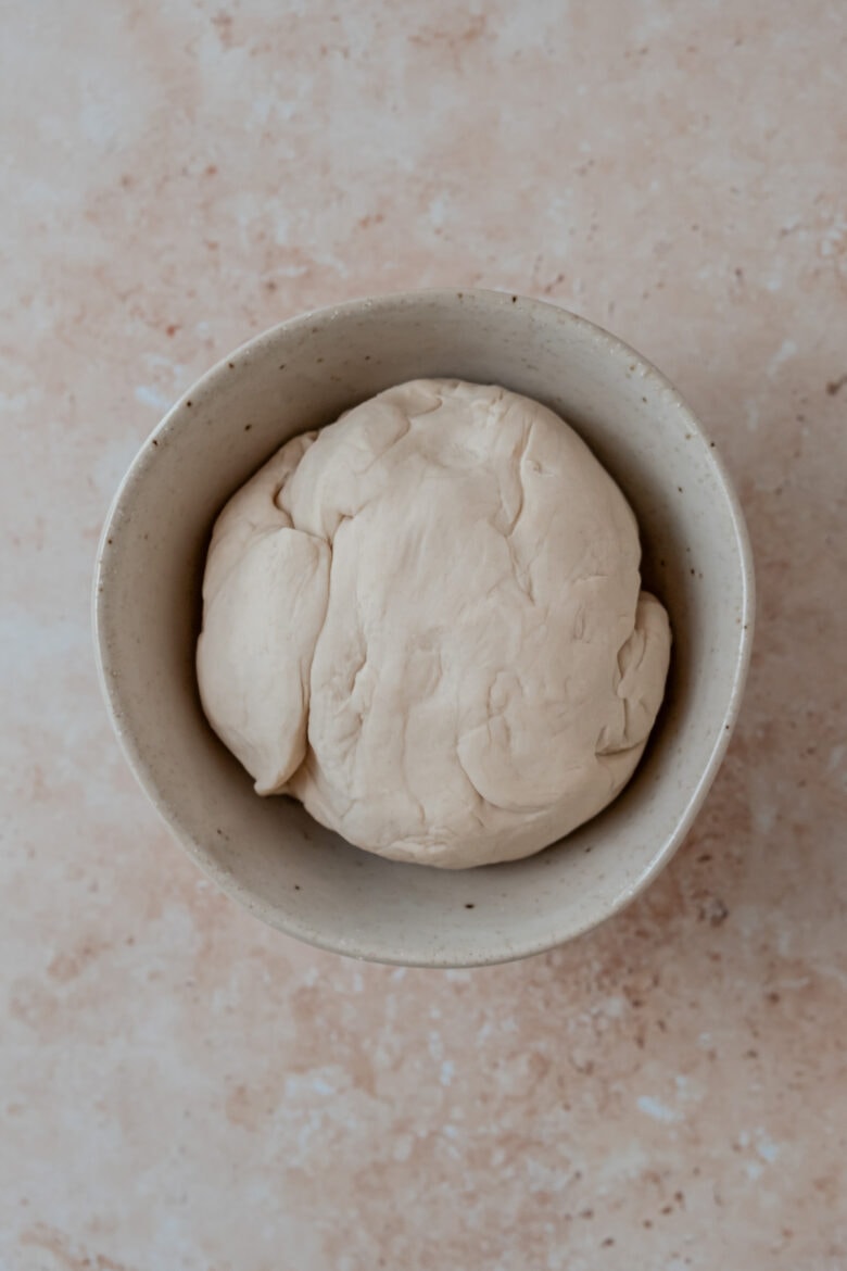 Dough in bowl before resting, showing tough texture.
