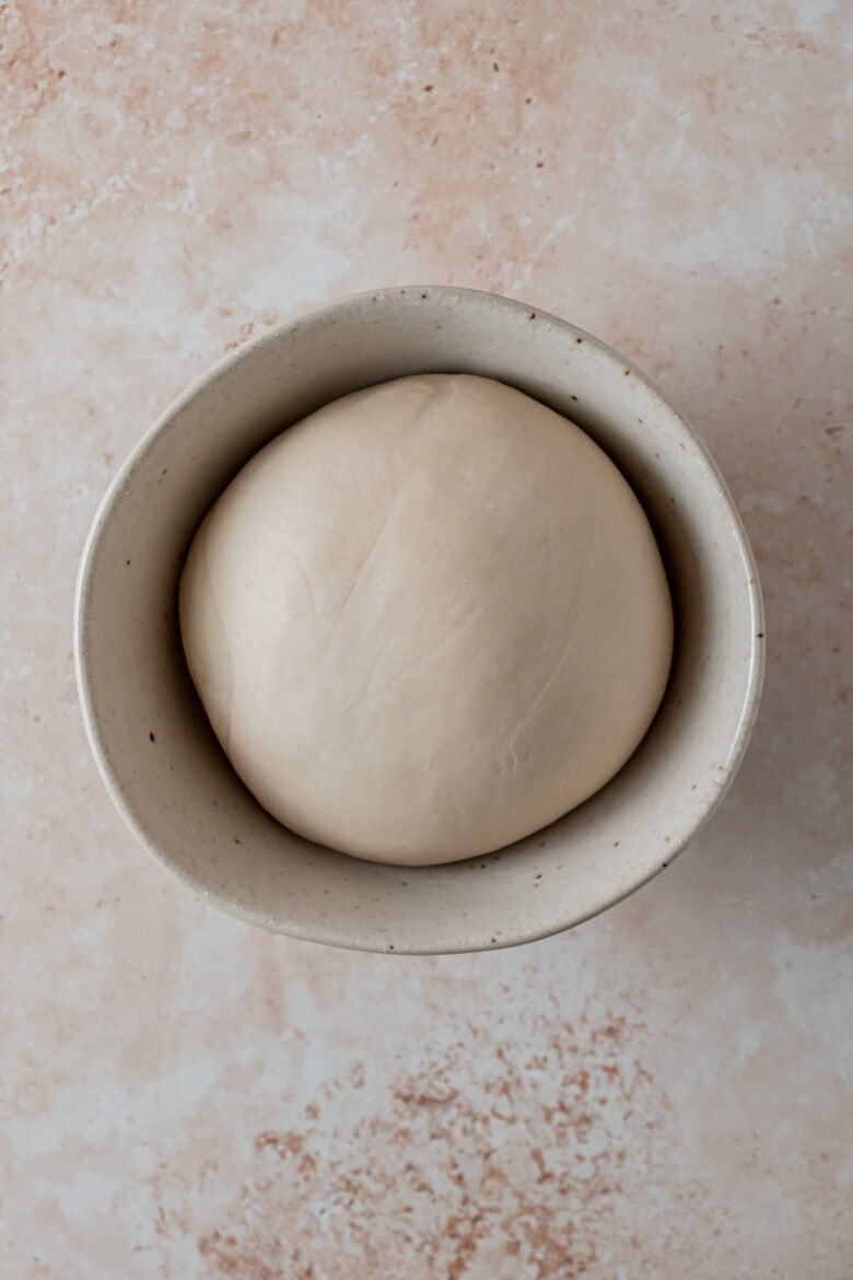 Smooth and elastic dough in bowl after resting.