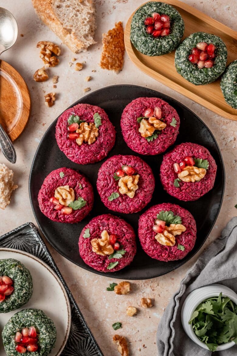Colorful Pkhali with beets and spinach arranged on various trays and served with crusty bread.