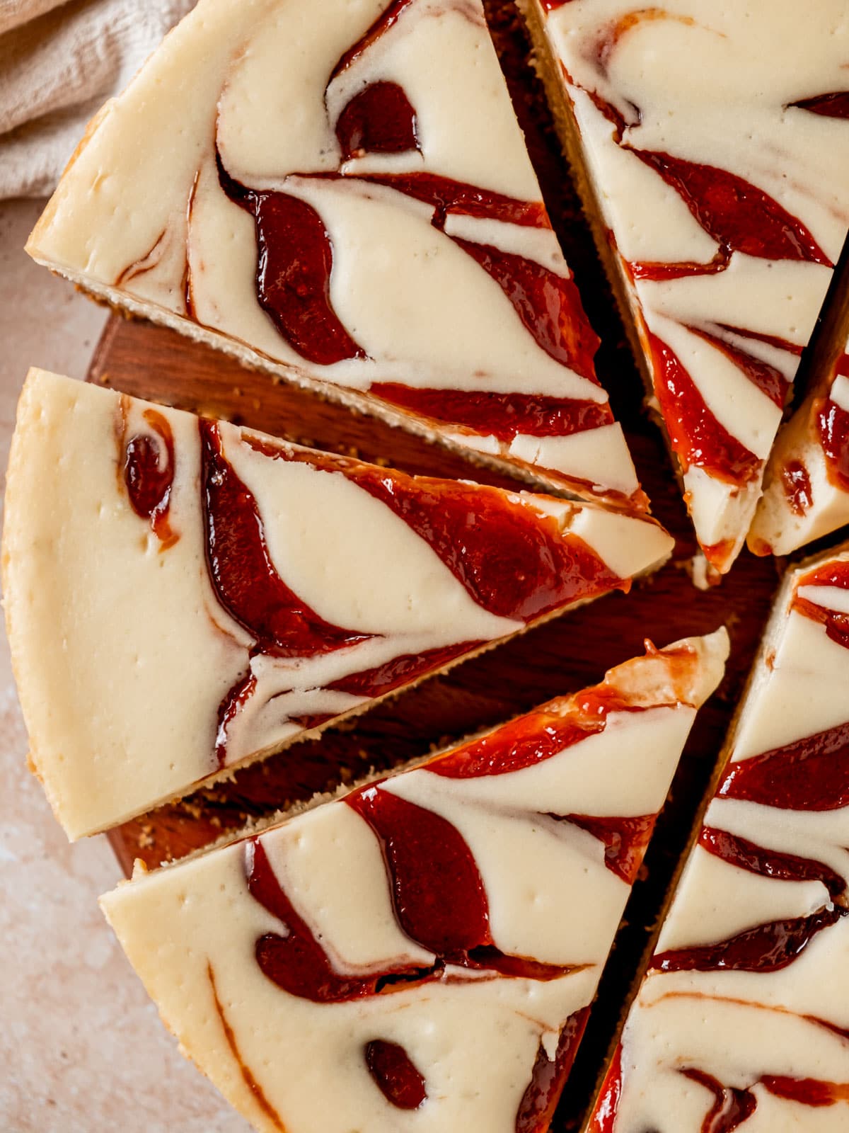 Overhead view of baked cheesecake slices with guava swirl.