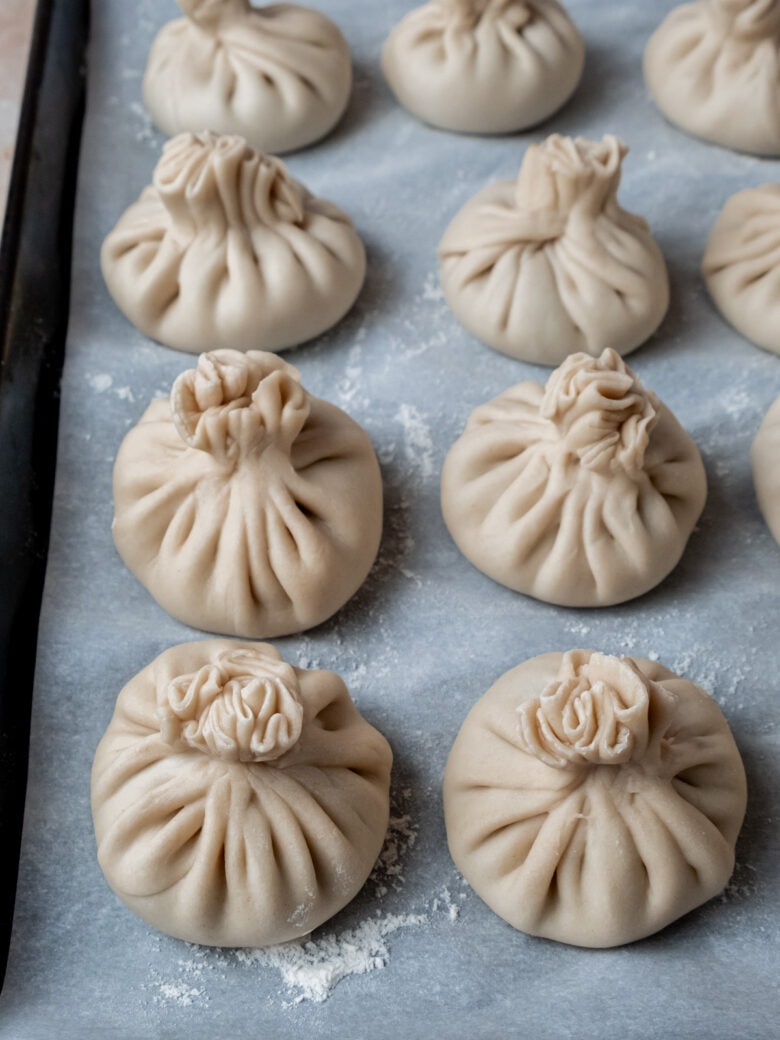 Formed dumplings on baking sheet lined with parchment paper and dusted with flour.