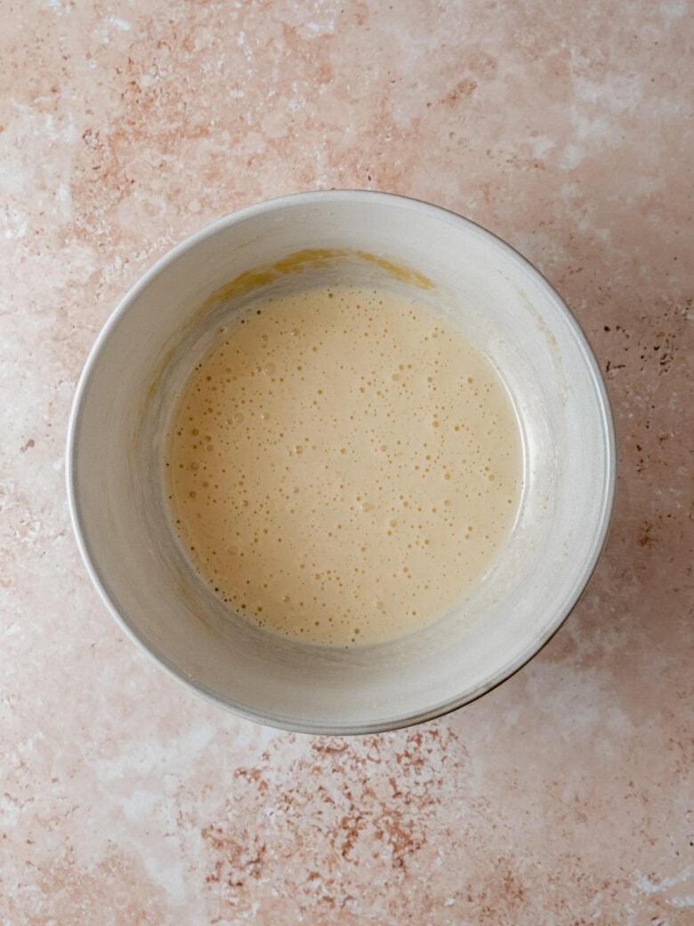 Frothy egg and sugar mixture in bowl.