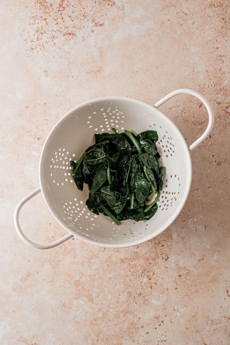 Blanched spinach in colander.