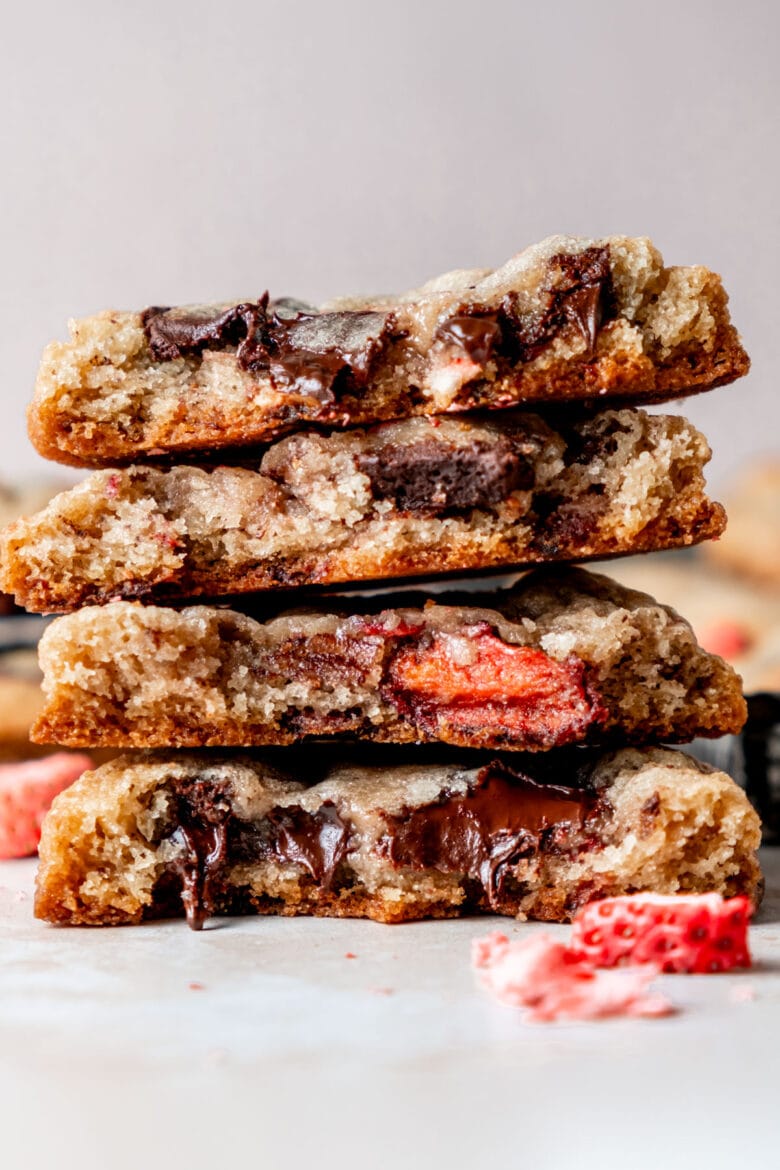 Stack of cookies cut in half to reveal melty chocolate and chewy strawberries.