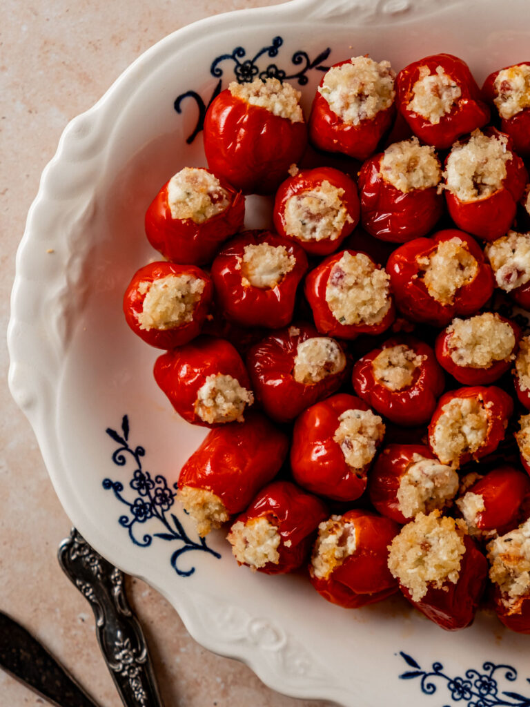Goat cheese stuffed Peppadews topped with panko on a serving platter.