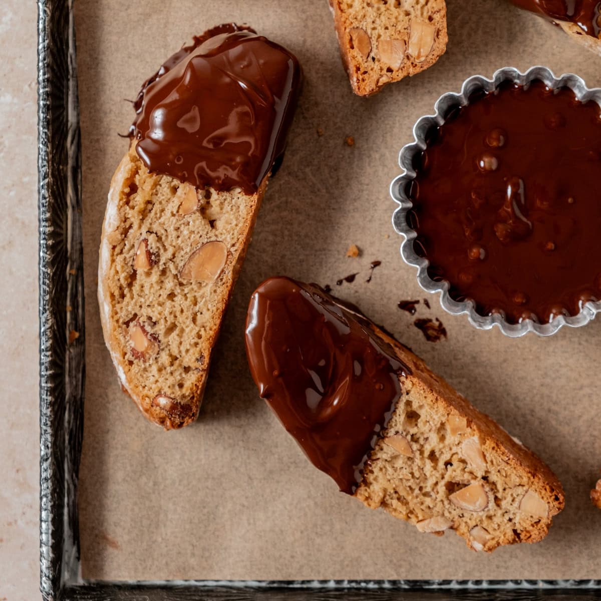 Almond biscotti dipped in chocolate on pan.