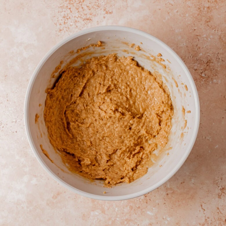 Adding eggs and vanilla extract to cookie dough.