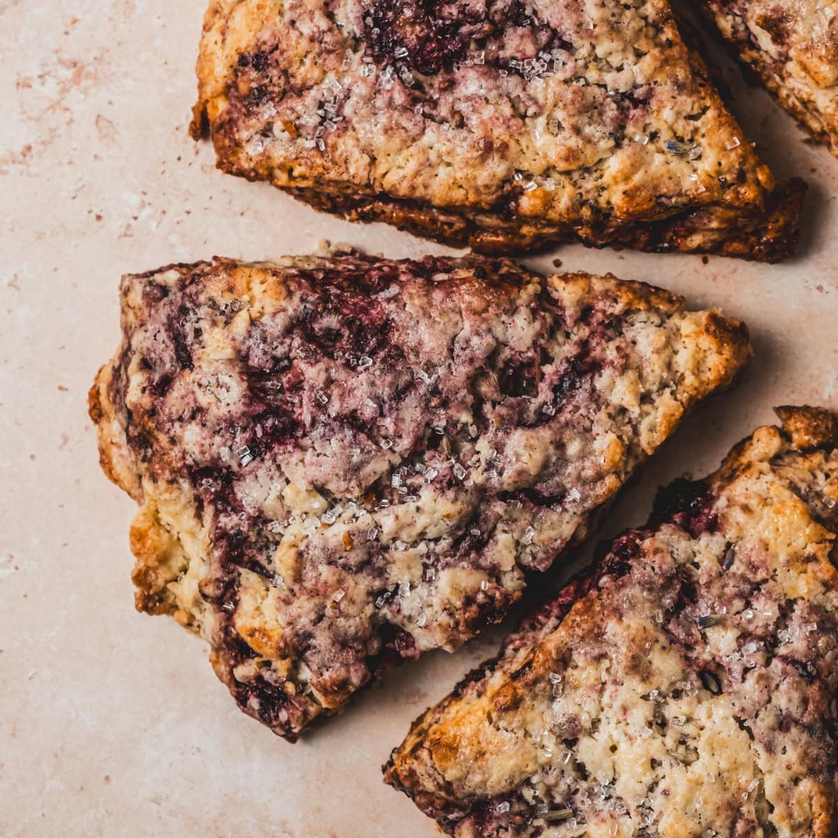Freshly baked scones with vibrant blackberry swirls.