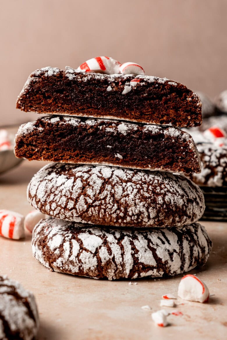 Stack of chocolate crinkle cookies topped with crushed peppermint.