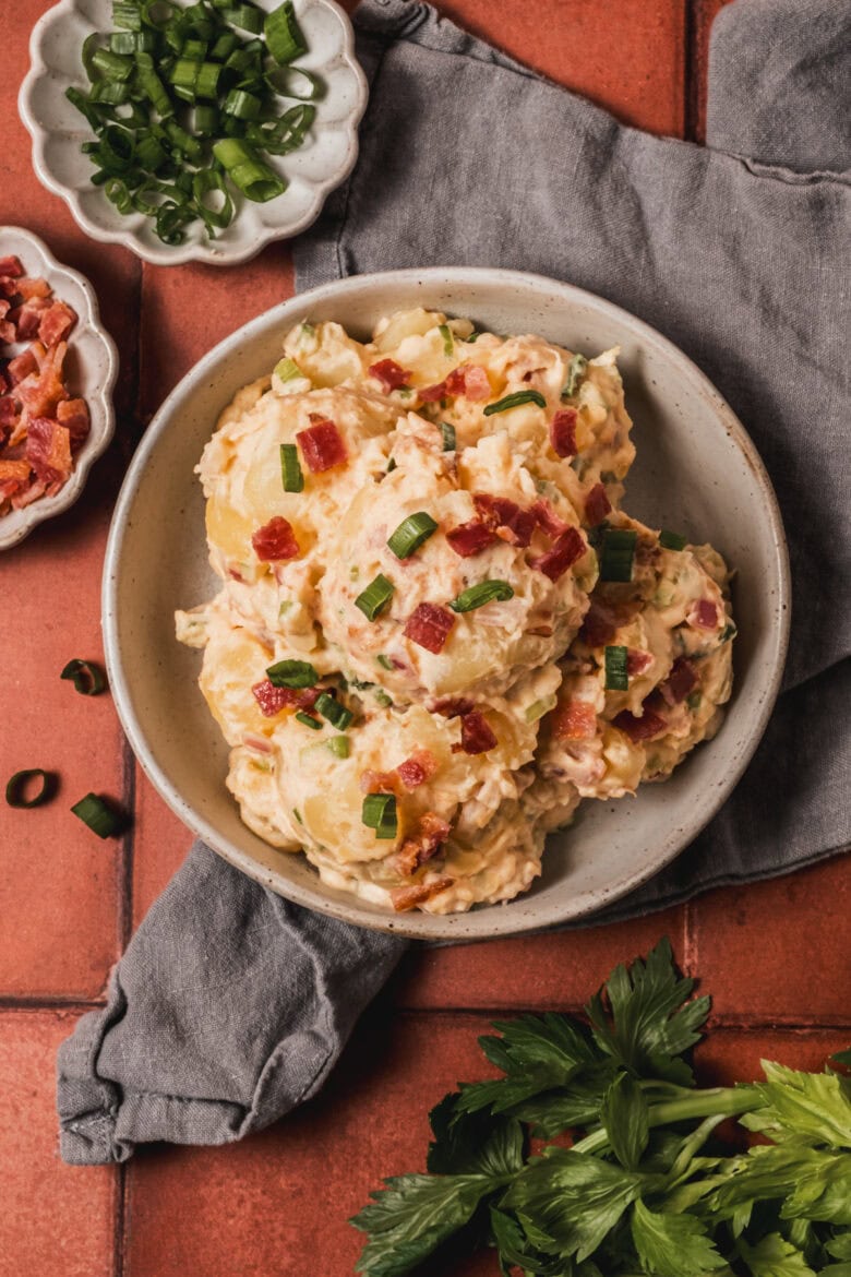 Potato salad plated with garnishes.