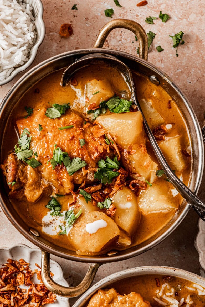 Yellow chicken curry in dish topped with cilantro.